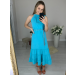 Vestido confeccionado em um tecido leve, fluido e que não amassa. Possui decote de amarração com detalhe franzido e dois cordões. Acompanha um cinto trançado das mesmas cores da peça. Sua saia tem comprimento midi e três babados. 